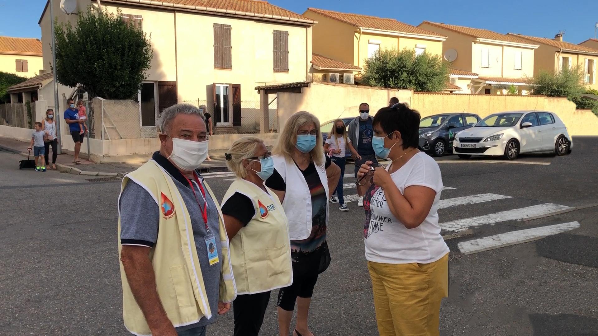 Claude domi et marcelle echangent avec une dame avant collecte devant l ecole de montady